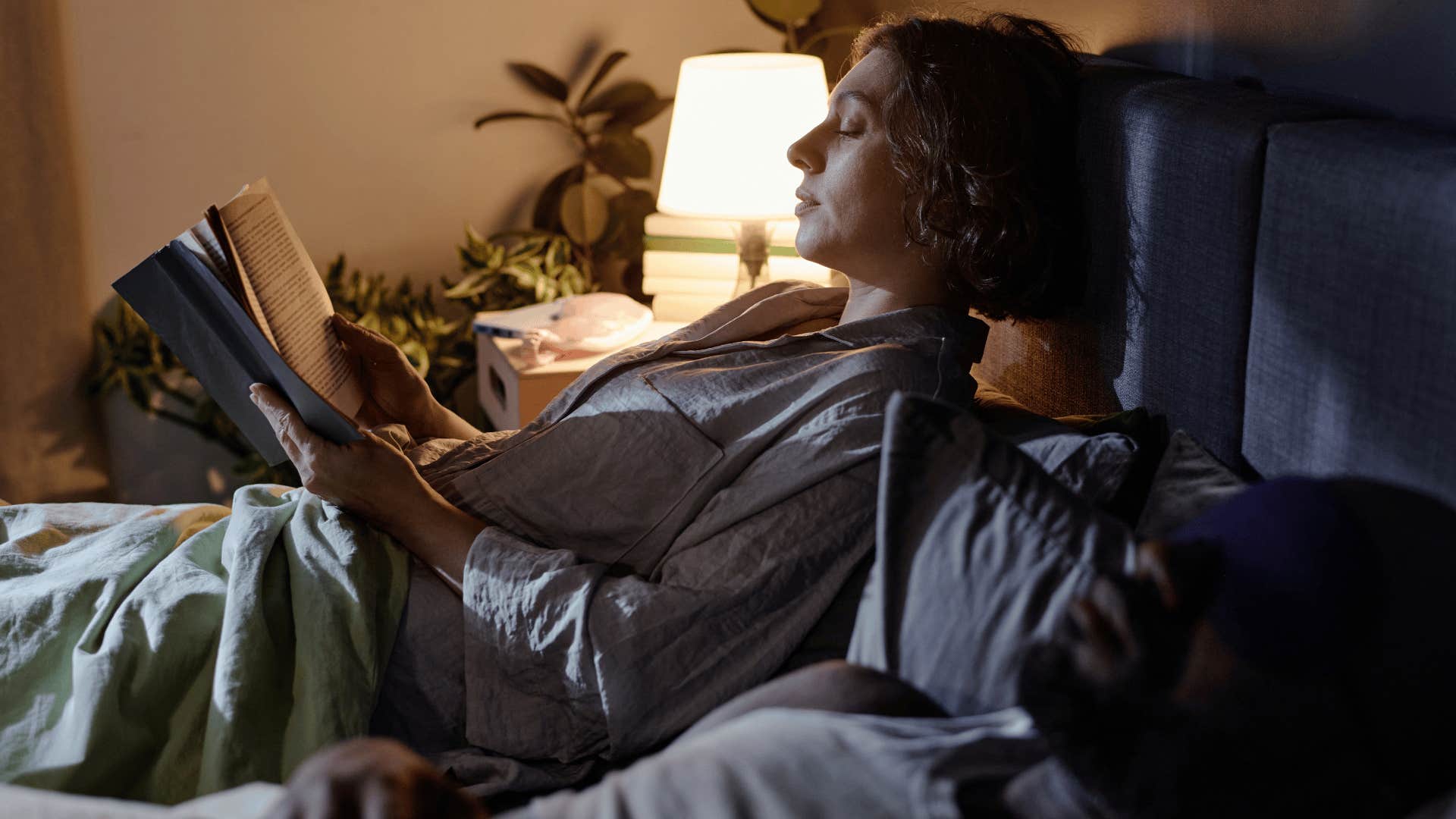 woman reading on bed as she has more autonomy over nighttime schedule