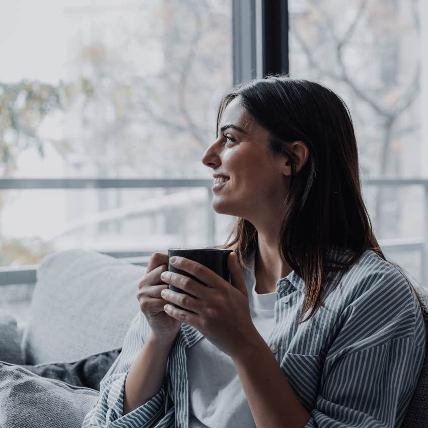 well-rested woman happily drinking morning coffee at home