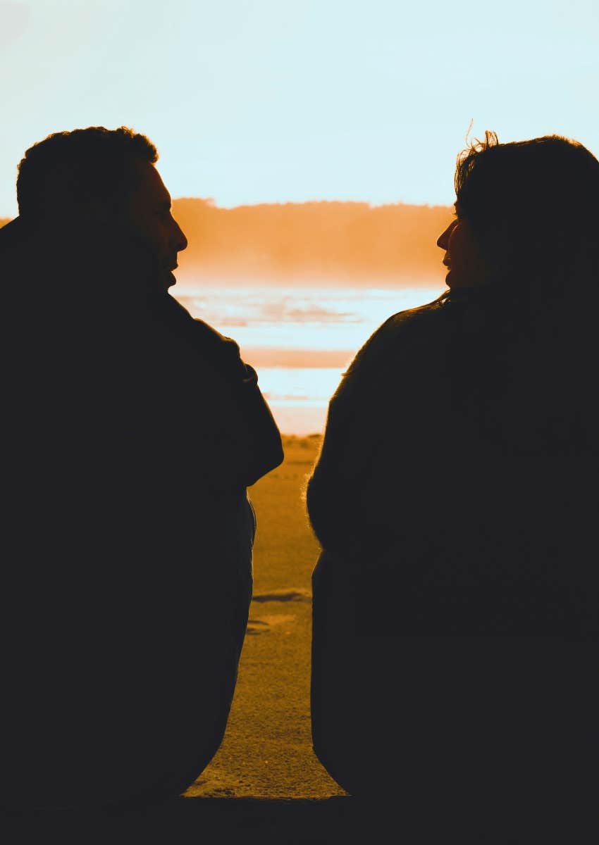 silhouette of couple talking at the beach