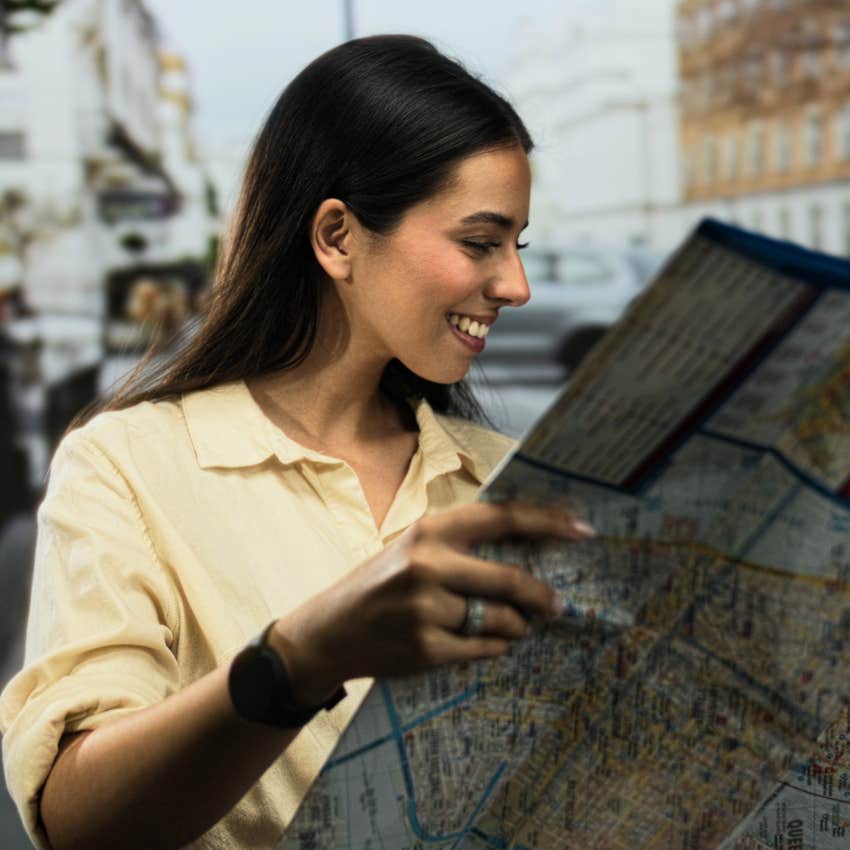 woman looking at printed directions for driving