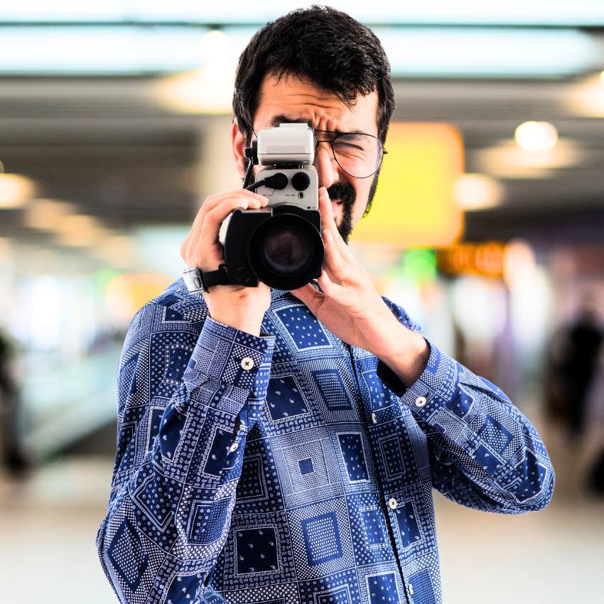 man taking a photo using vintage camera where film has to be developed