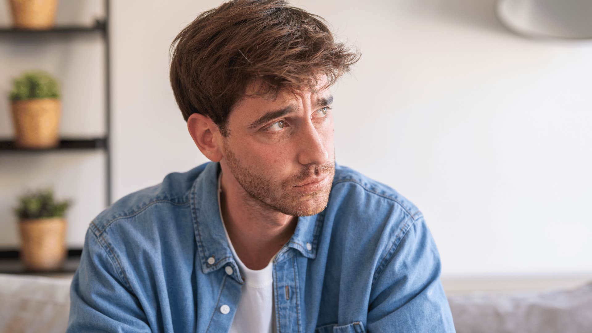 sad man blaming himself sitting at home alone