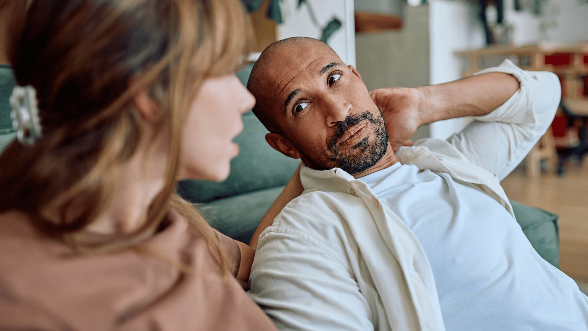 man who seems less engaged in conversation with his partner at home