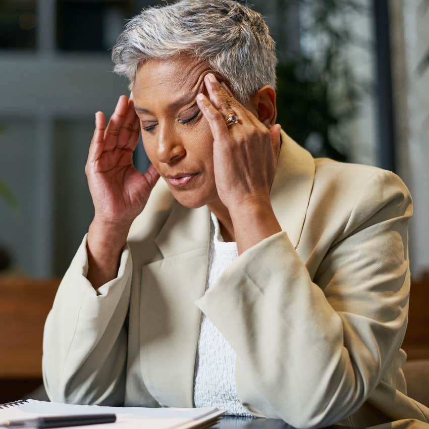 woman who struggles with setting realistic expectations looking stressed at work