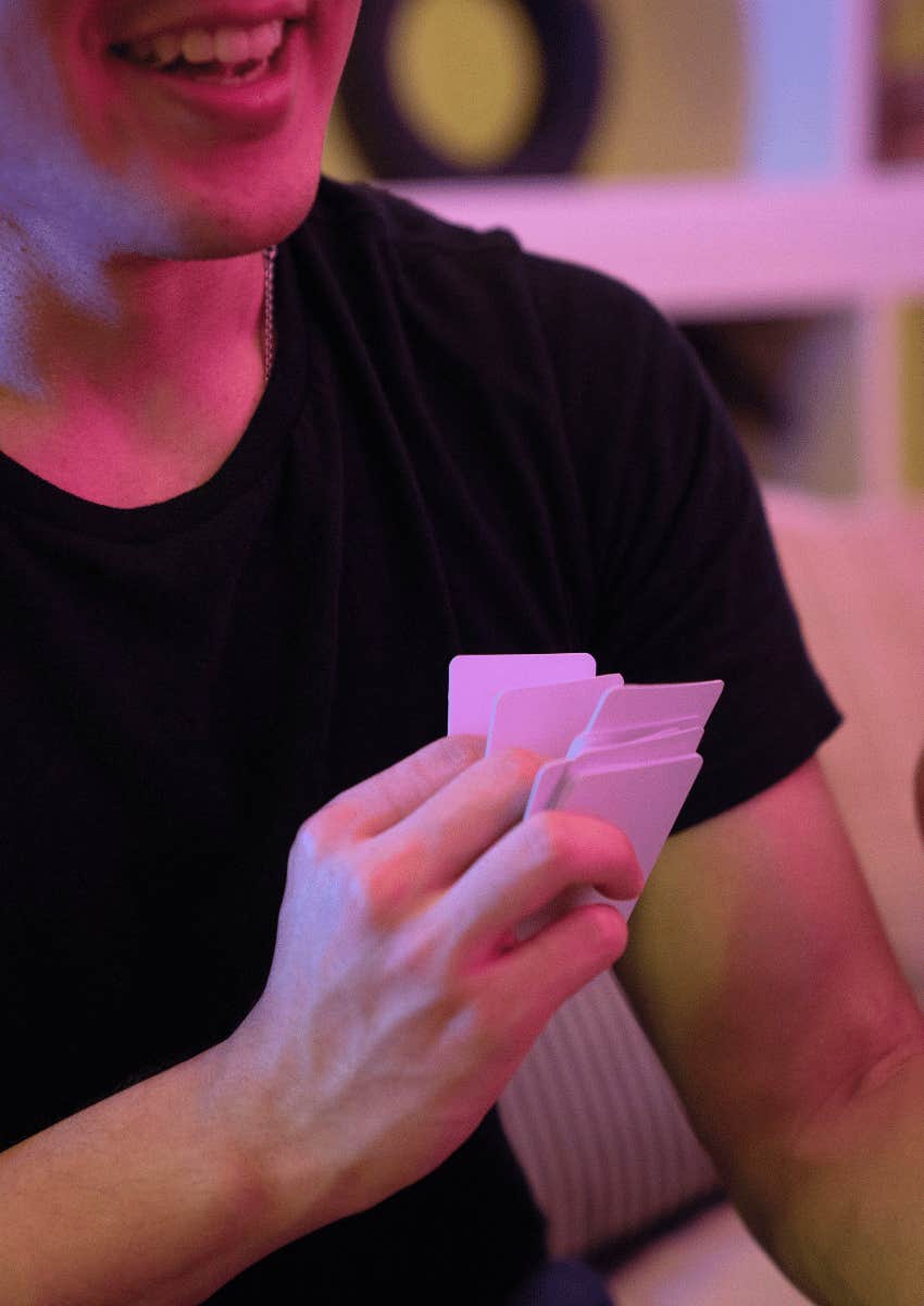 smiling man holding game cards