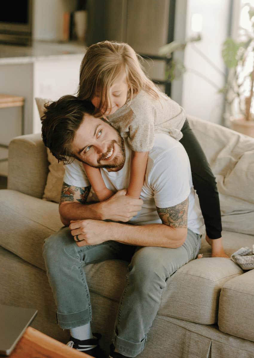 smiling man playing with a young girl