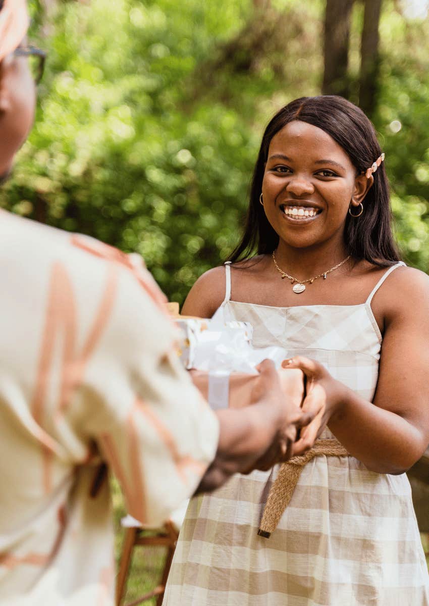 smiling woman accepting gift from a man