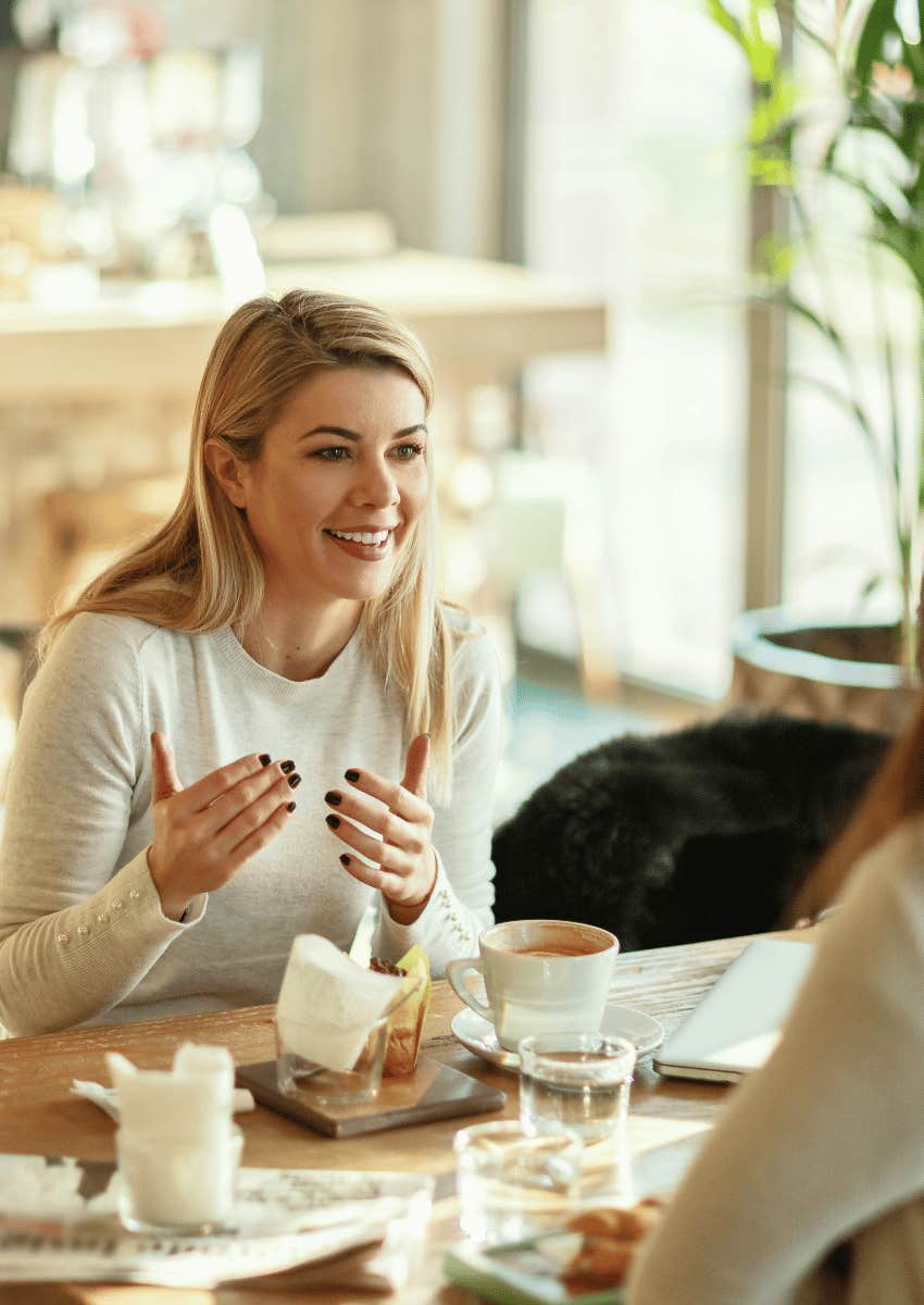 smiling woman talking to her friend over breakfast