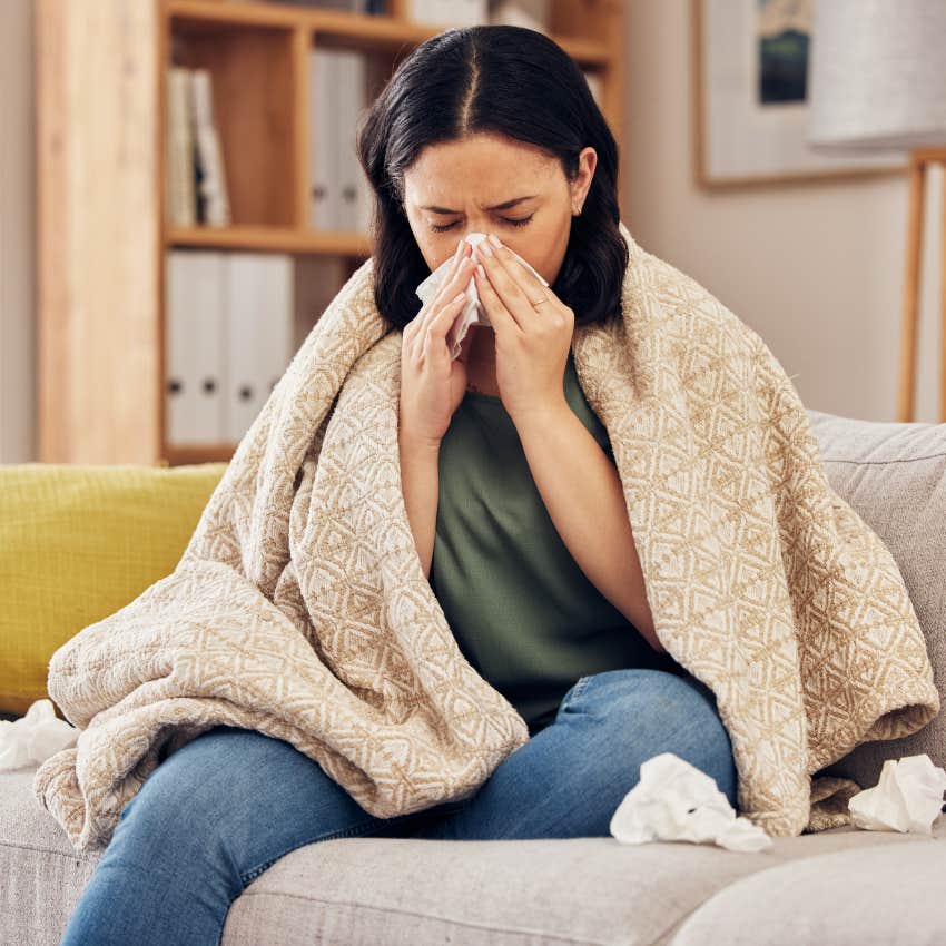 woman blowing her nose feeling sick because of stress