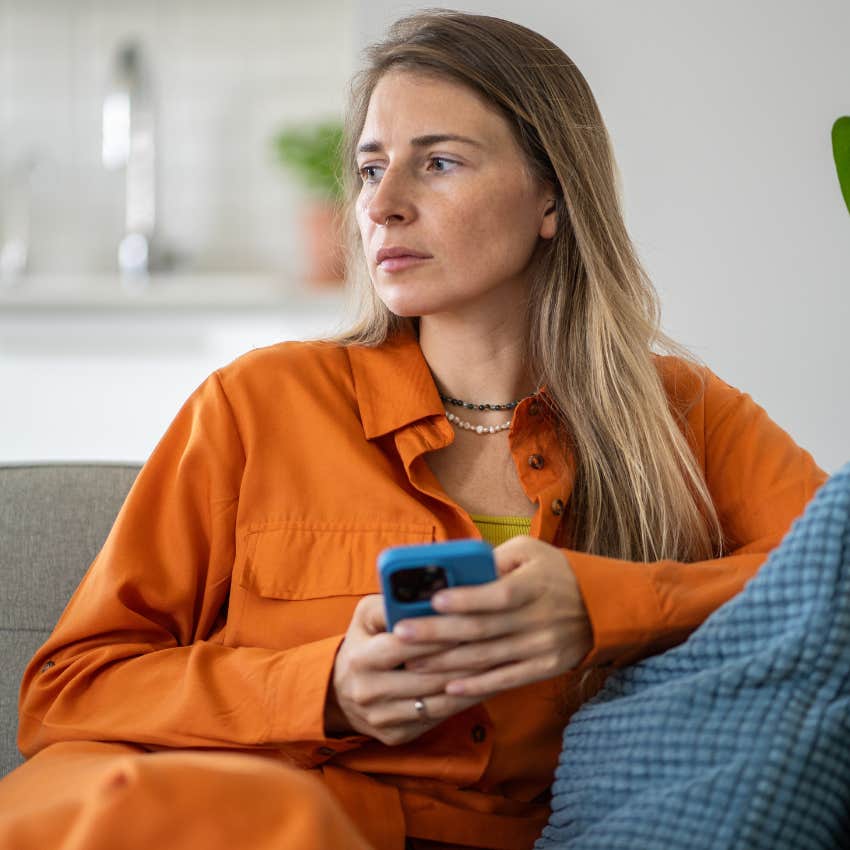 exhausted woman on her couch texting 
