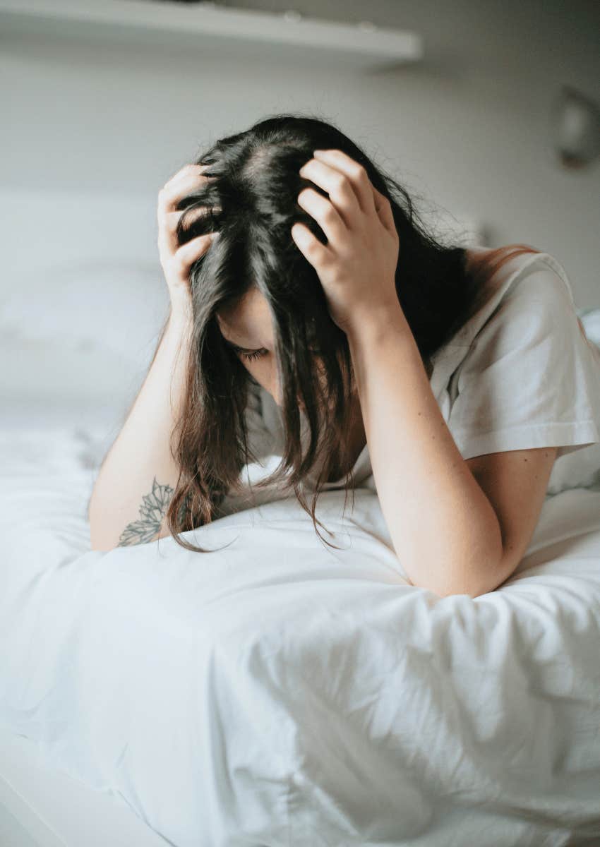 stressed woman looking down with her head in her hands