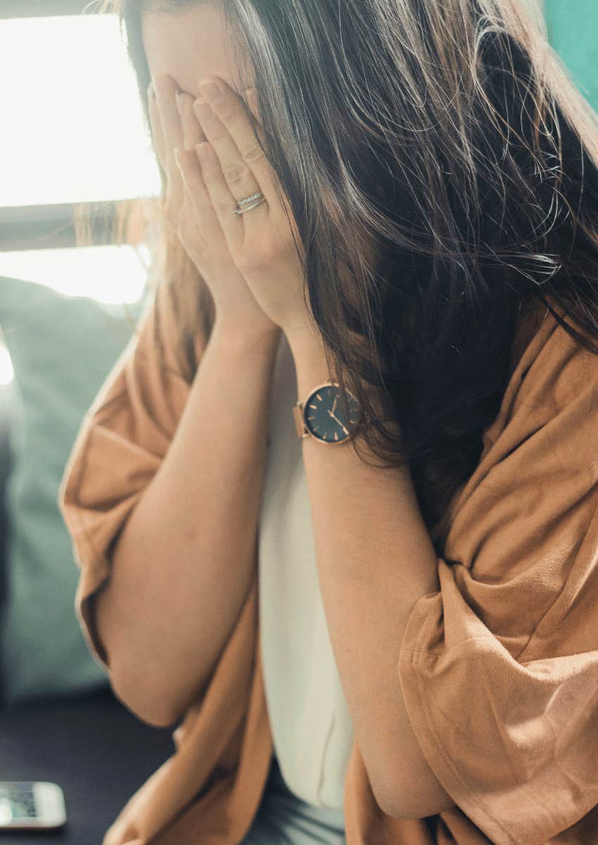 struggling woman covering her face