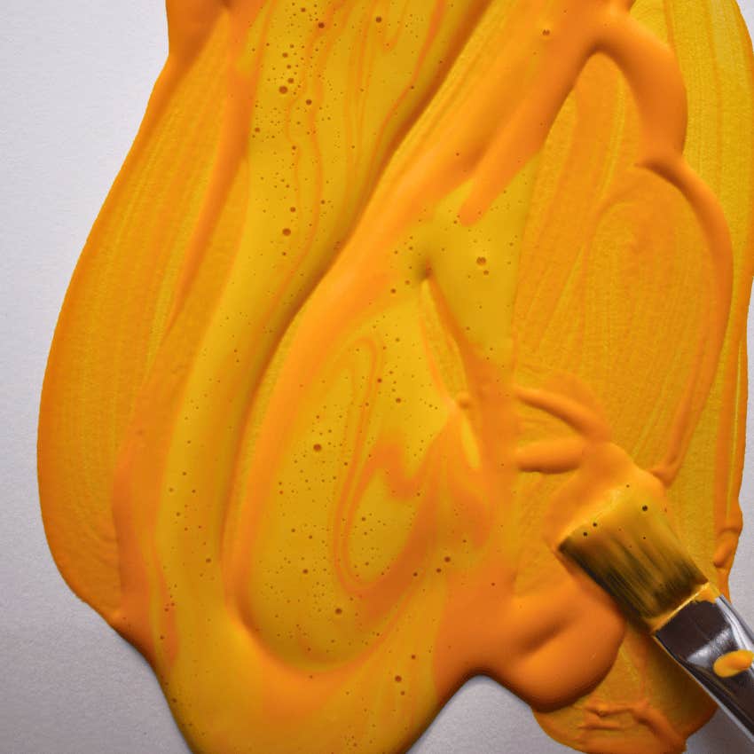 sun orange paint color mixed by paintbrush