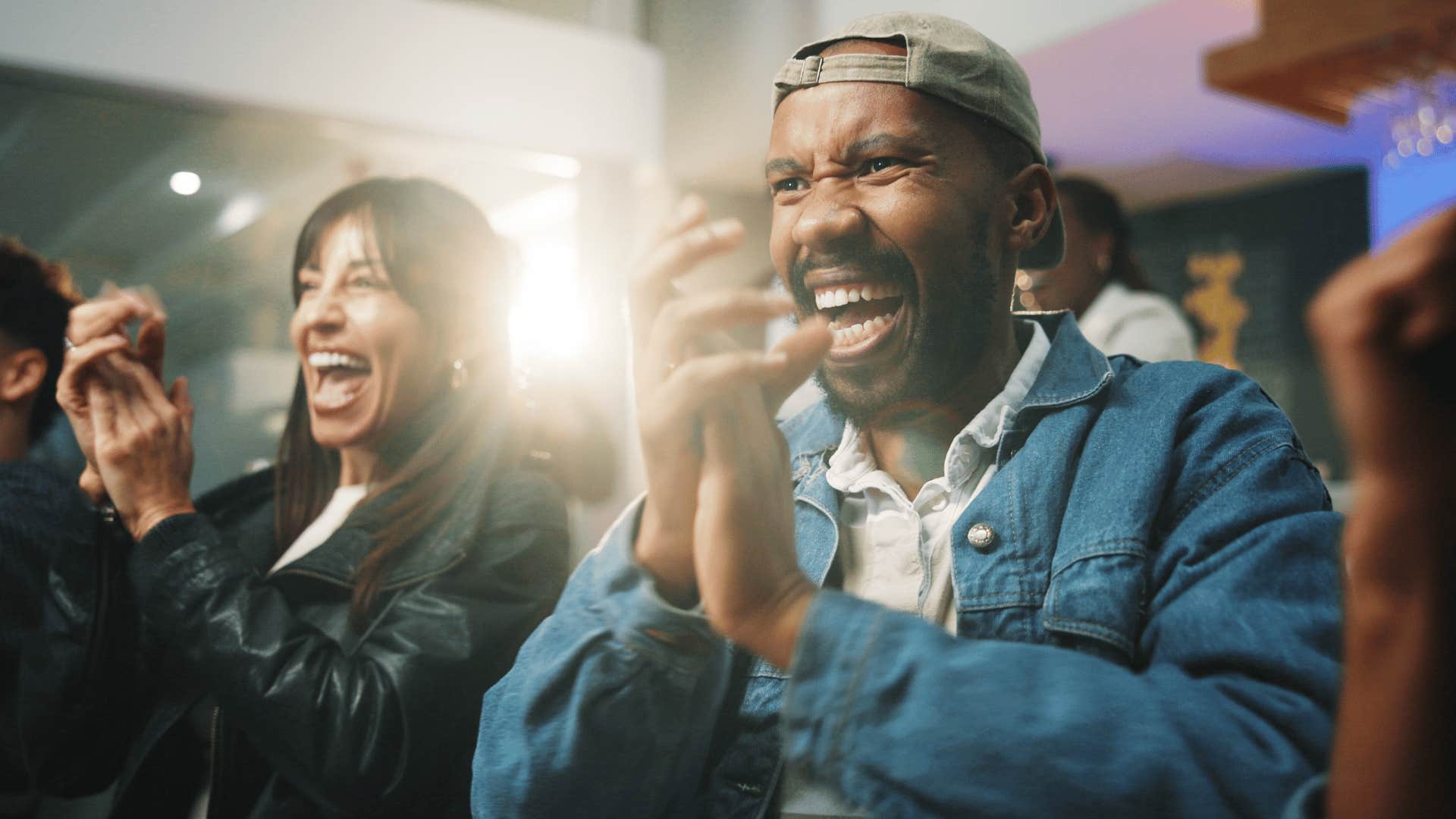 man clapping in crowd telling friend i'm rooting for you