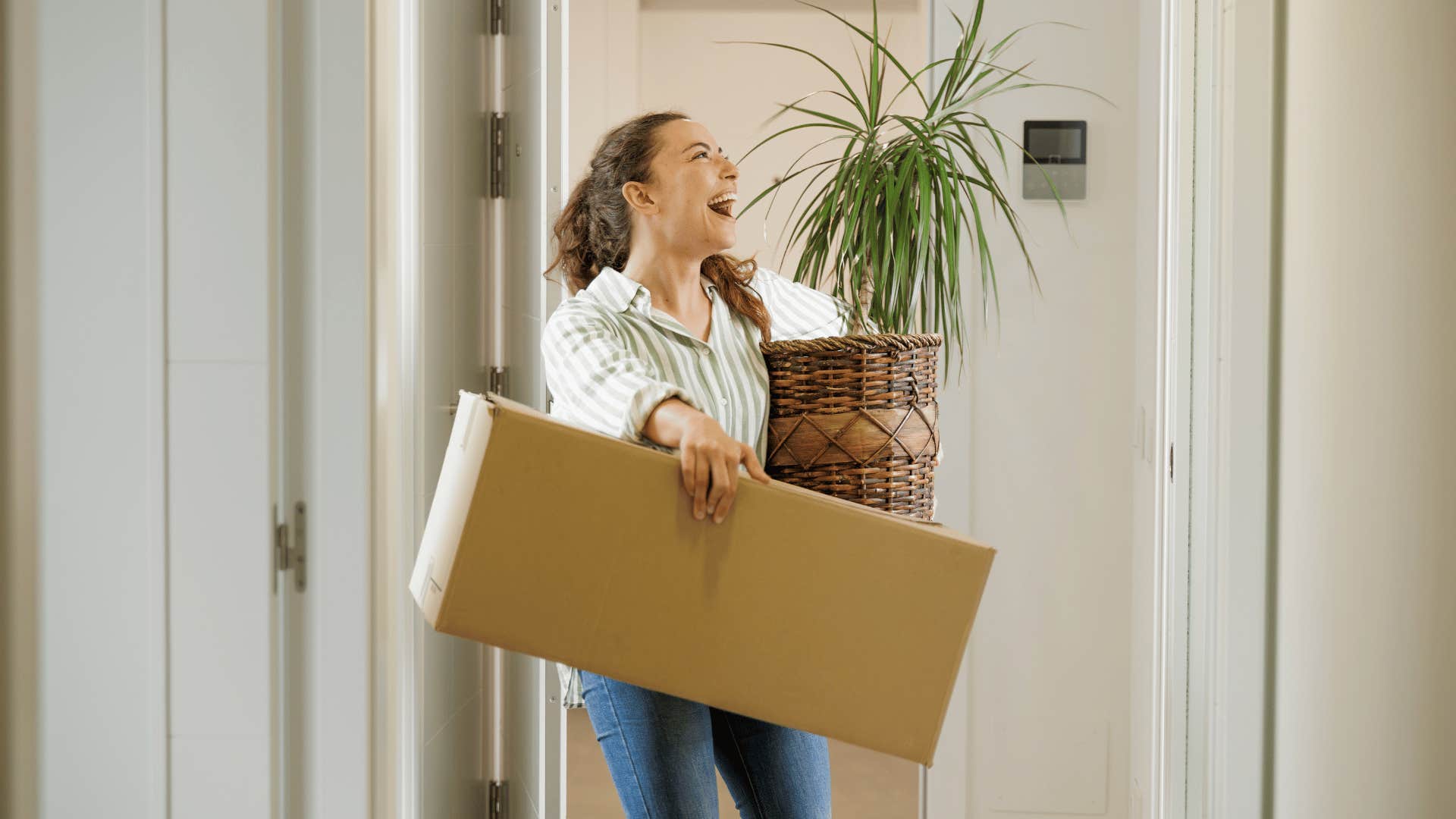 woman holding boxes moving into a new home