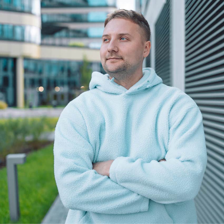 gen z man standing outside embracing being alone