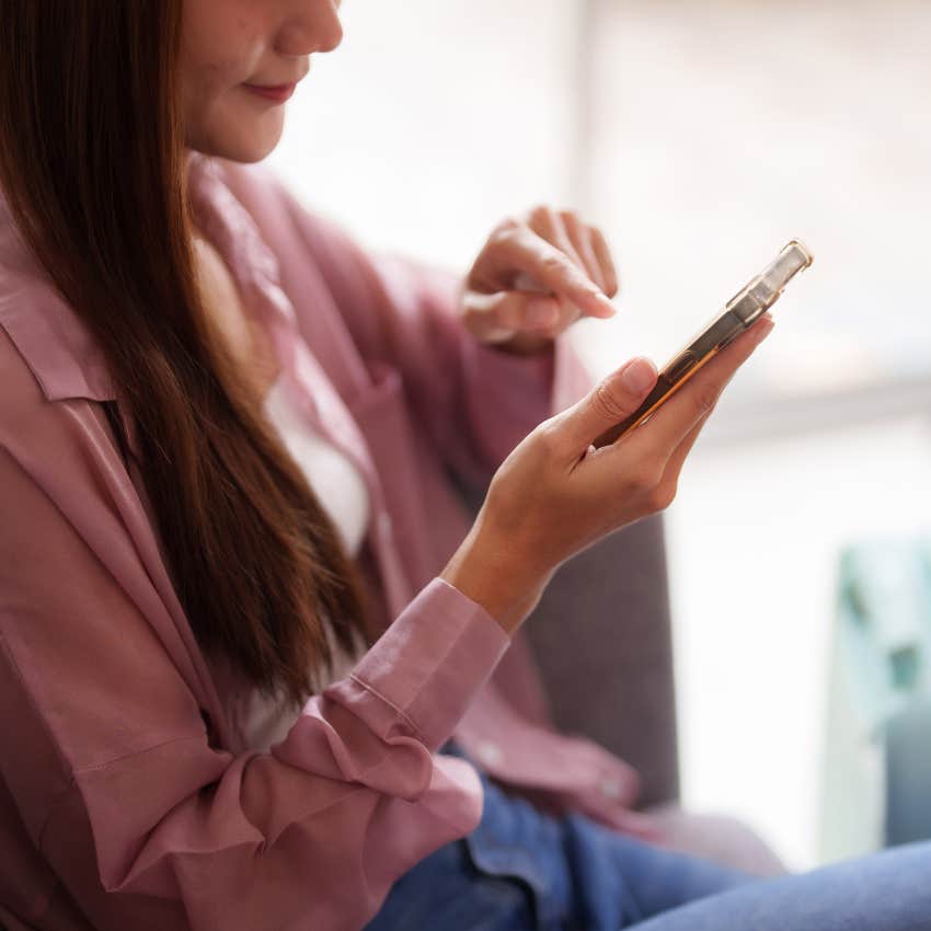 woman checking her phone because she's more attached to someone than she wants to admit