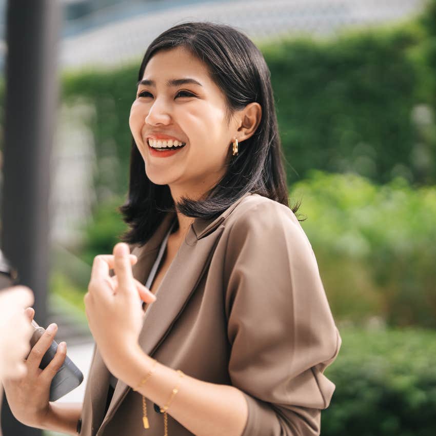people-pleasing woman laughing off something bothering her