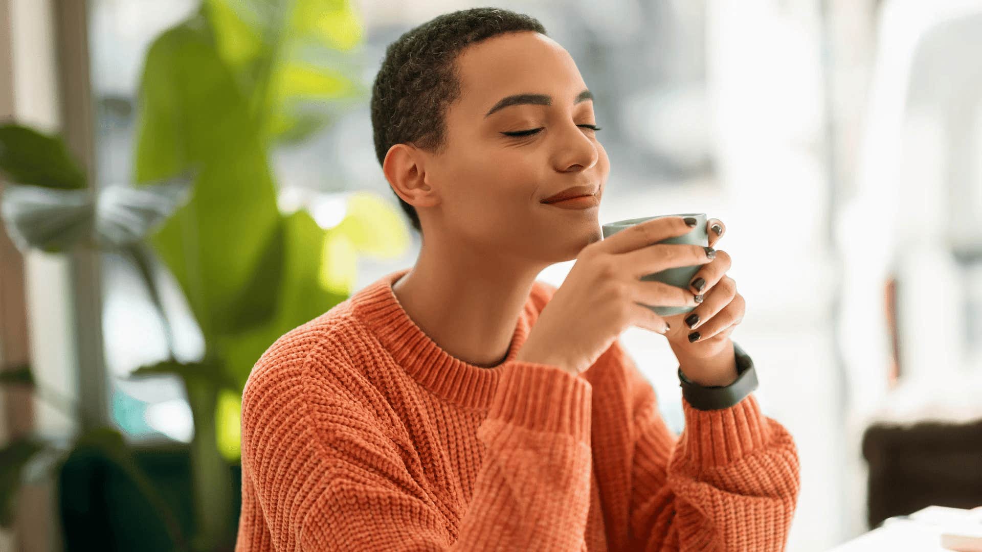 grateful woman drinking coffee relaxing at home