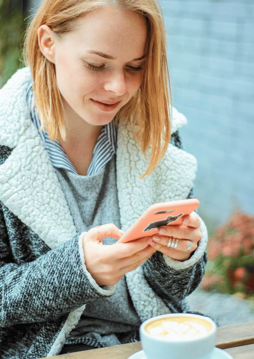 woman texting, smiling down at phone