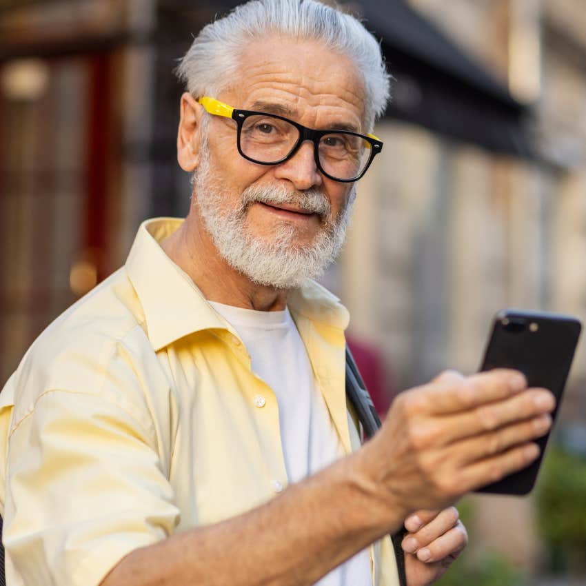 man sharing his child's success on social media holding his phone