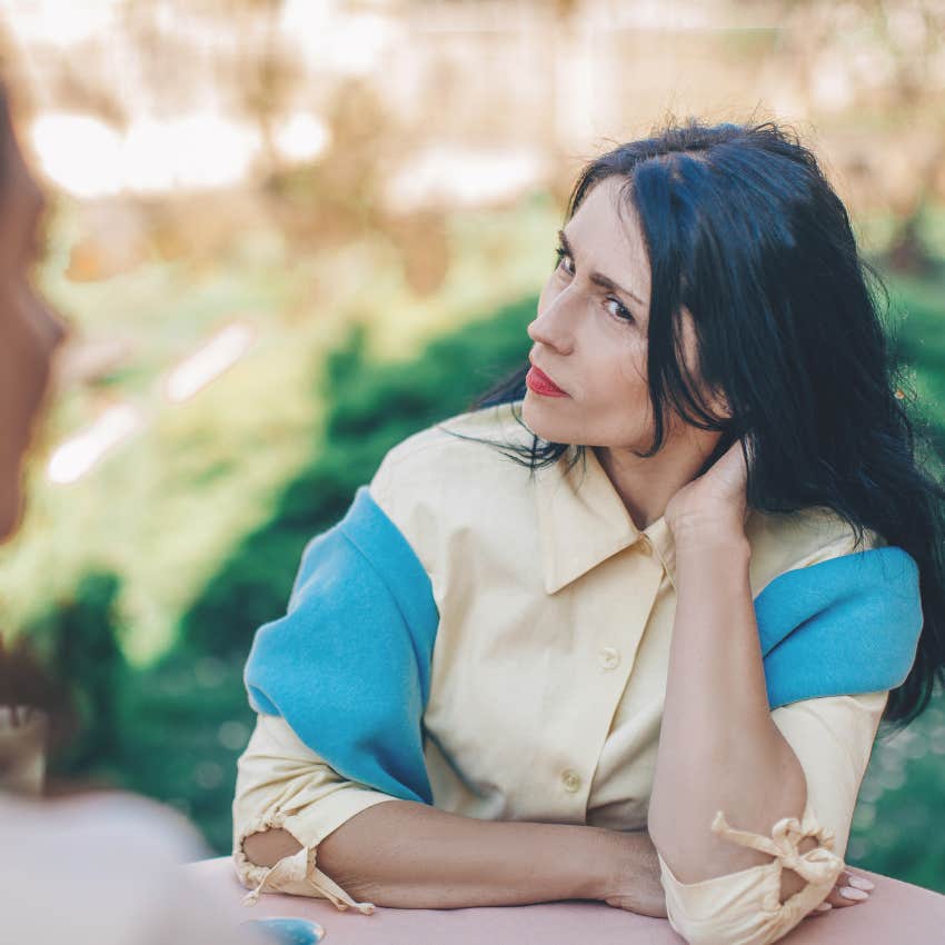 insecure woman dismissing threats in a conversation with a friend
