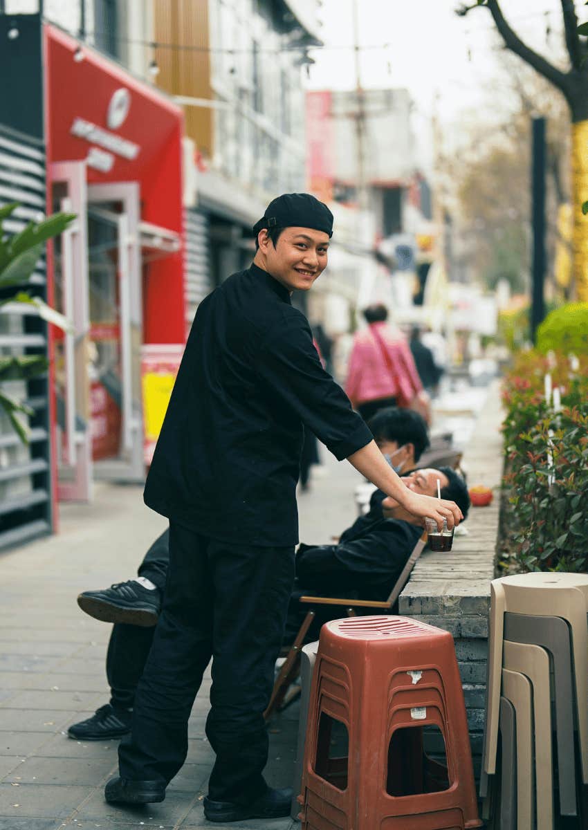 young smiling asian man offering seat to man