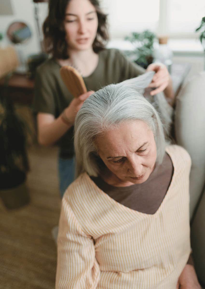 young woman brushing her elder's hair