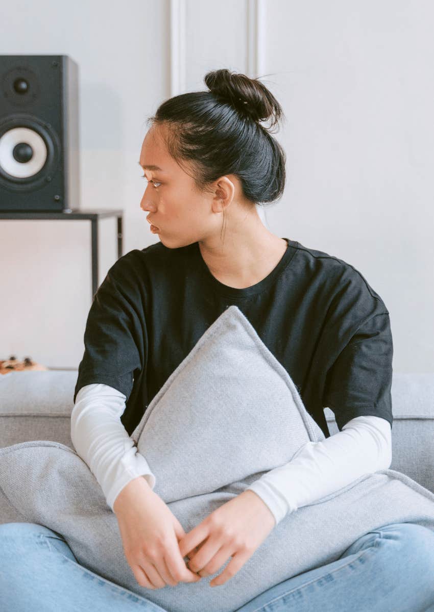 young woman sitting alone on a couch