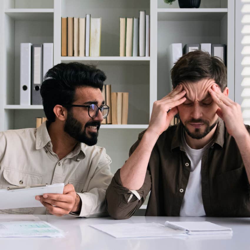 man looking annoyed by colleague talking about conspiracy theories at work