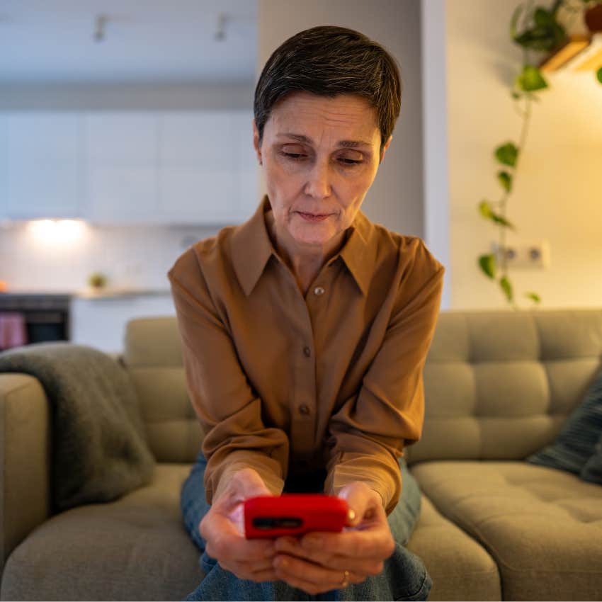 older woman looking at fake news on Facebook on her phone