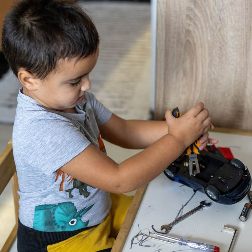 Child fixing a broken toy car alone