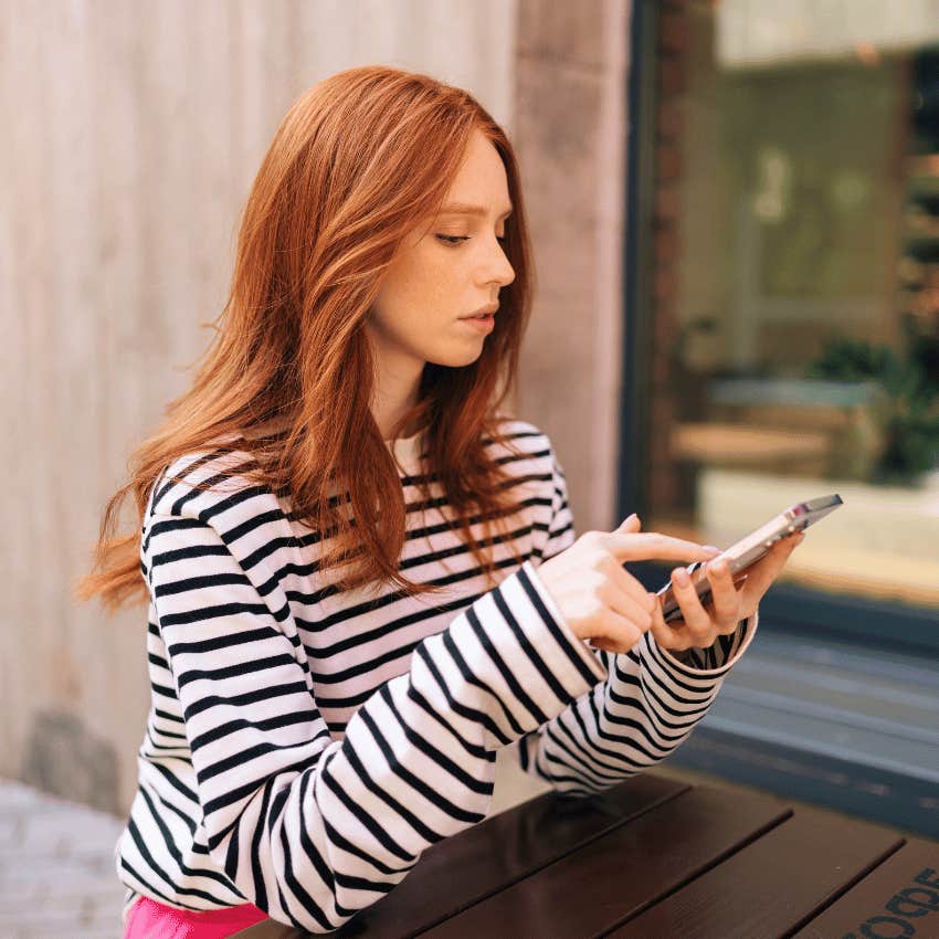 attractive young woman looking at her online dating profile