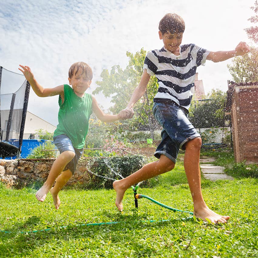 kids running through sprinkler on a hot day