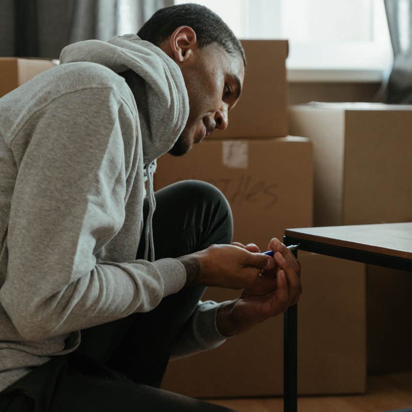 Man repairing a household item using basic tools while figuring out the solution through trial and error