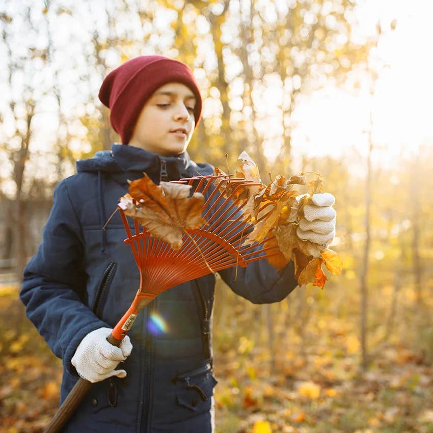 young boy raking leaves like kids did in the 70s & 80s to prepare for real life