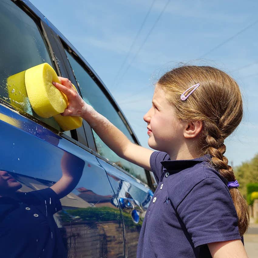 little girl doing boring weekend chore of washing car to help prep her for real life