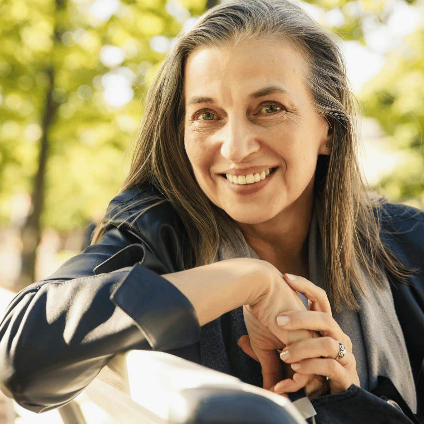 charismatic mature woman sitting on park bench