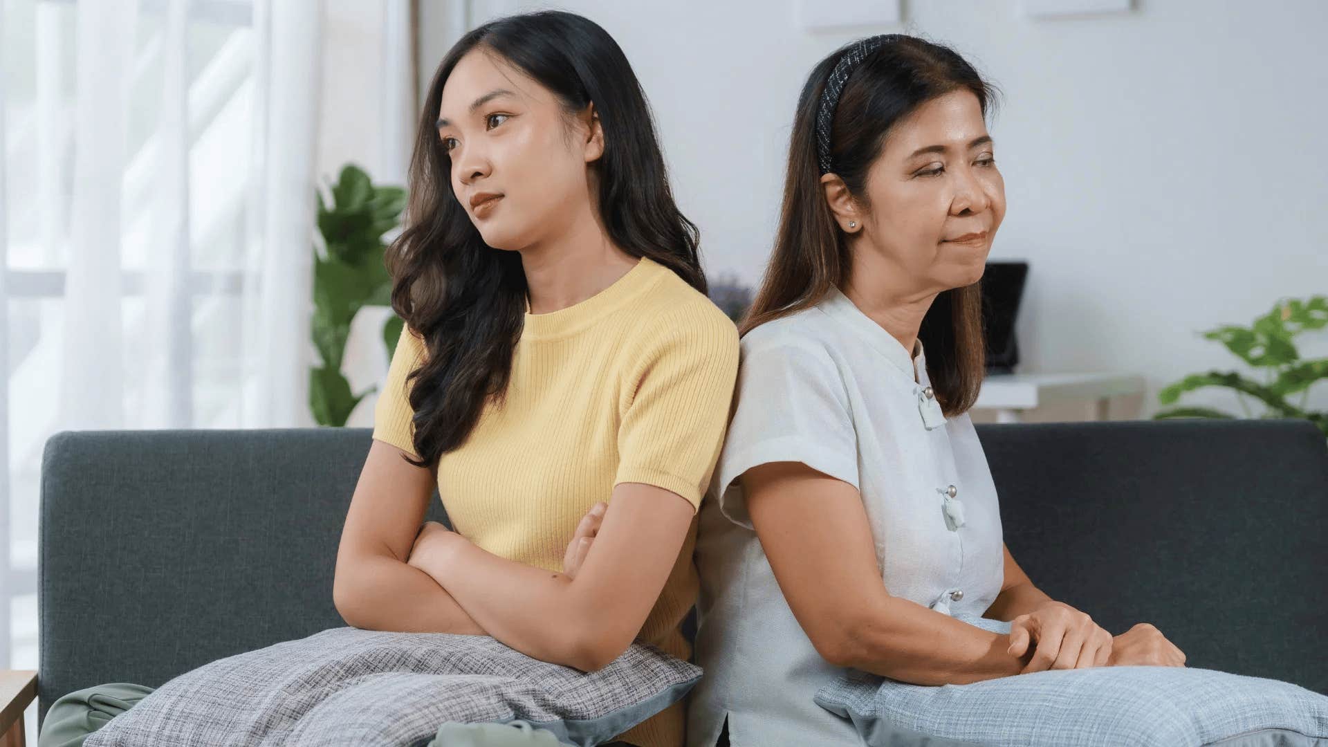 resentful young woman turned away from mom who uses her as a scapegoat