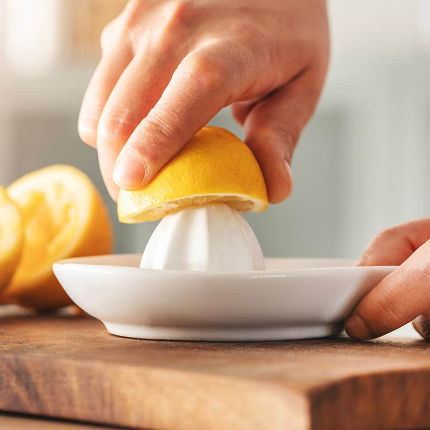 person hand juicing lemons for cooking
