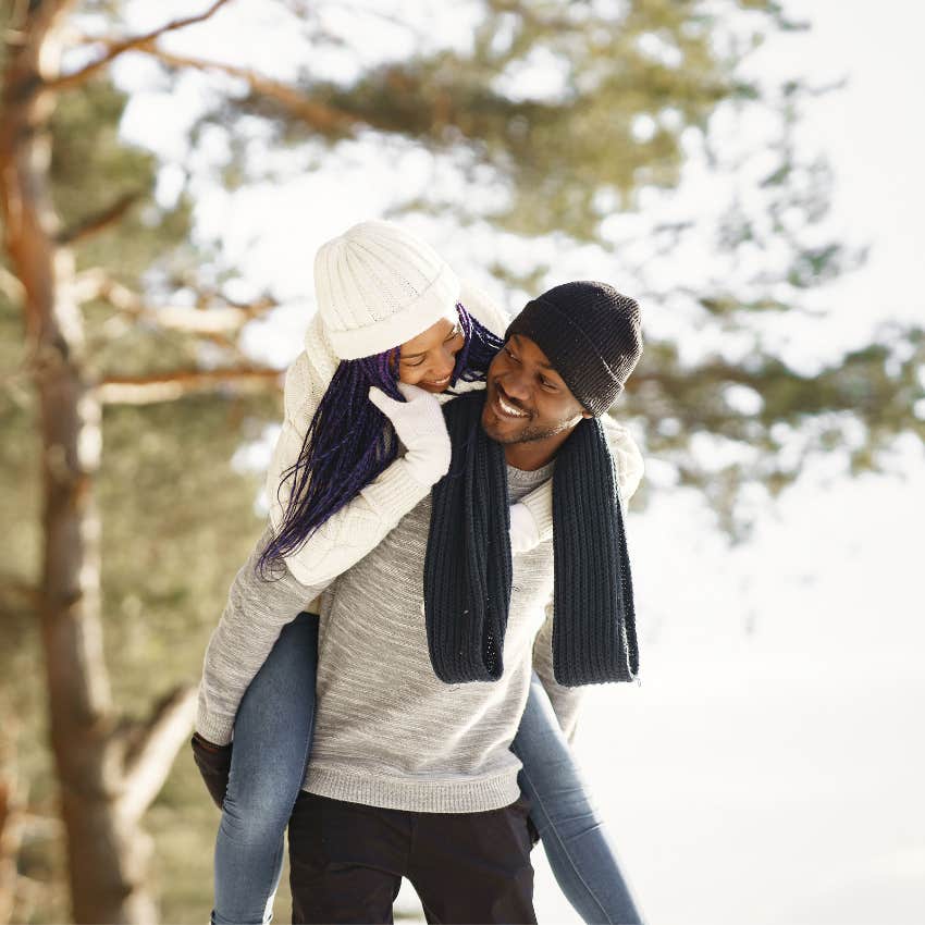 Couple smiling as one partner carries the other on a walk in a simple act of everyday kindness