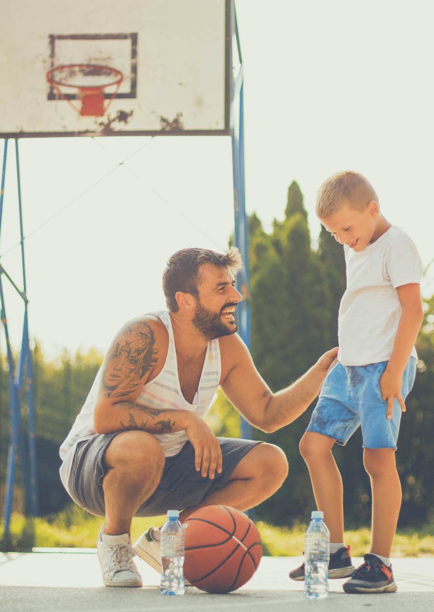 dad playing basketball outside with boy
