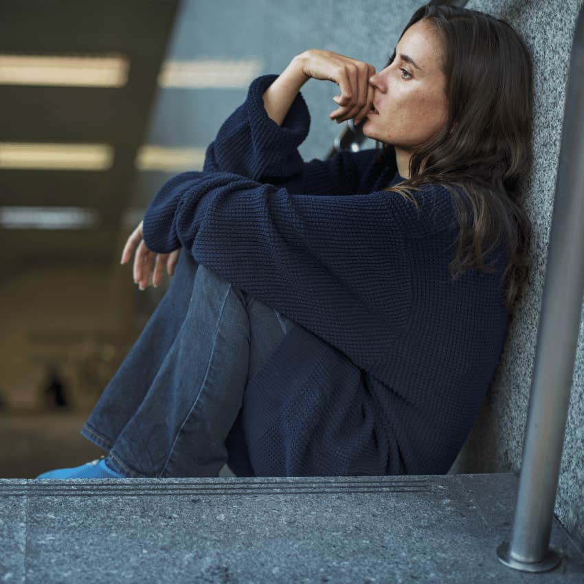 financially struggling woman sitting on the stairs