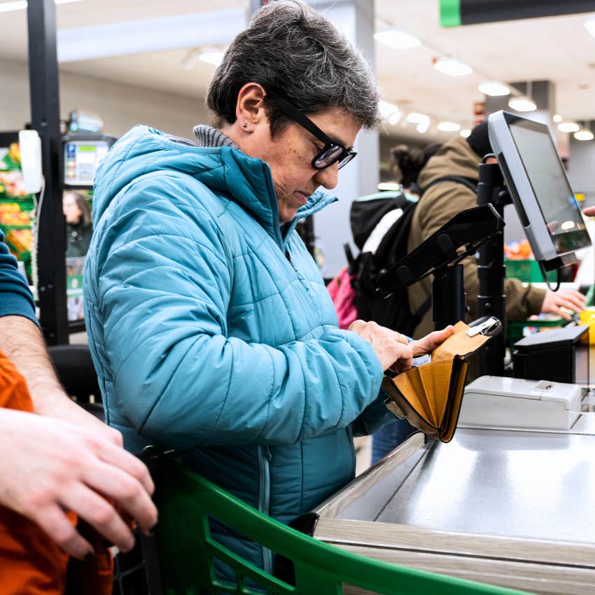 boomer woman using cash for everything at the checkout