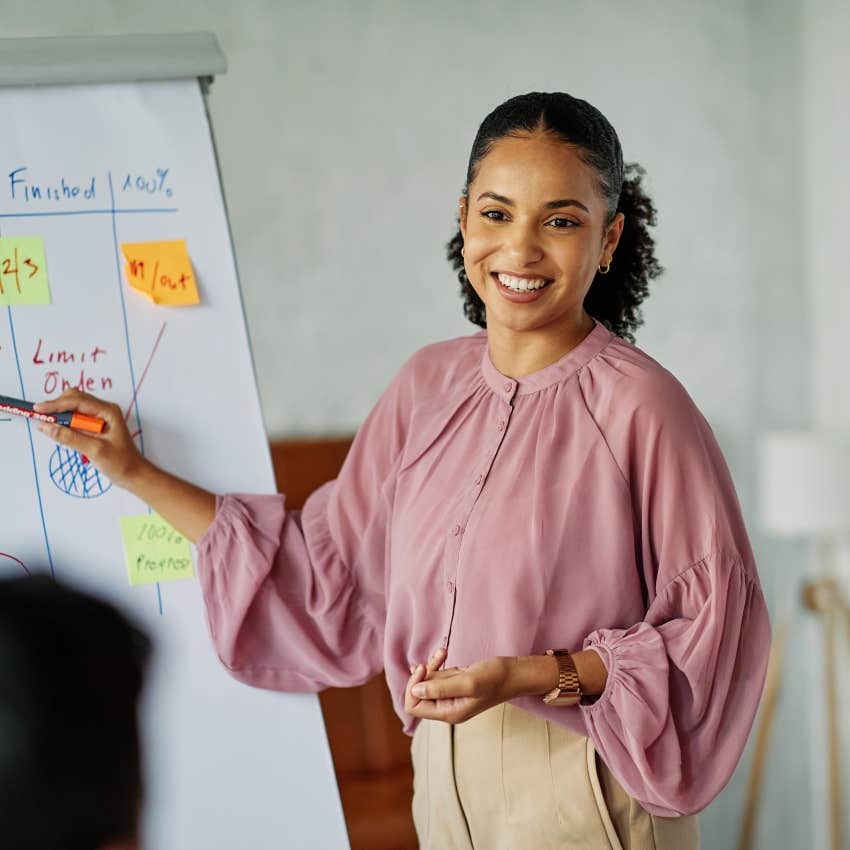 happy gen z woman giving a presentation at work