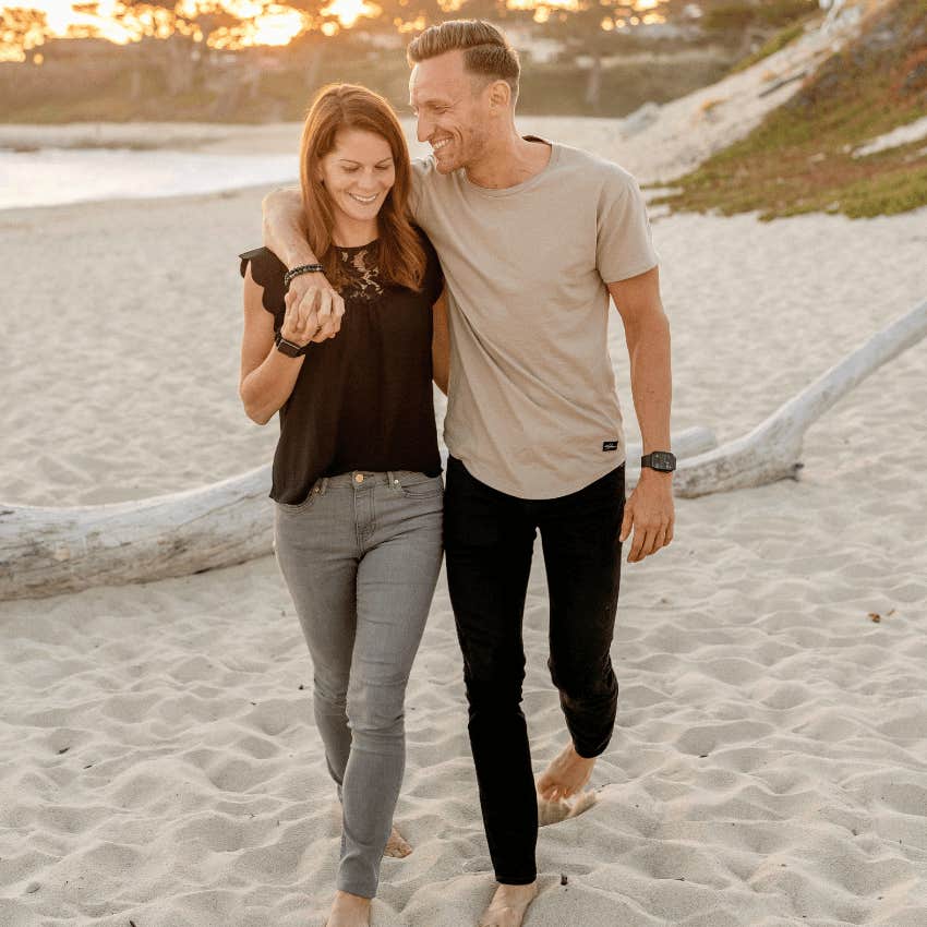 happy loving couple walking on beach