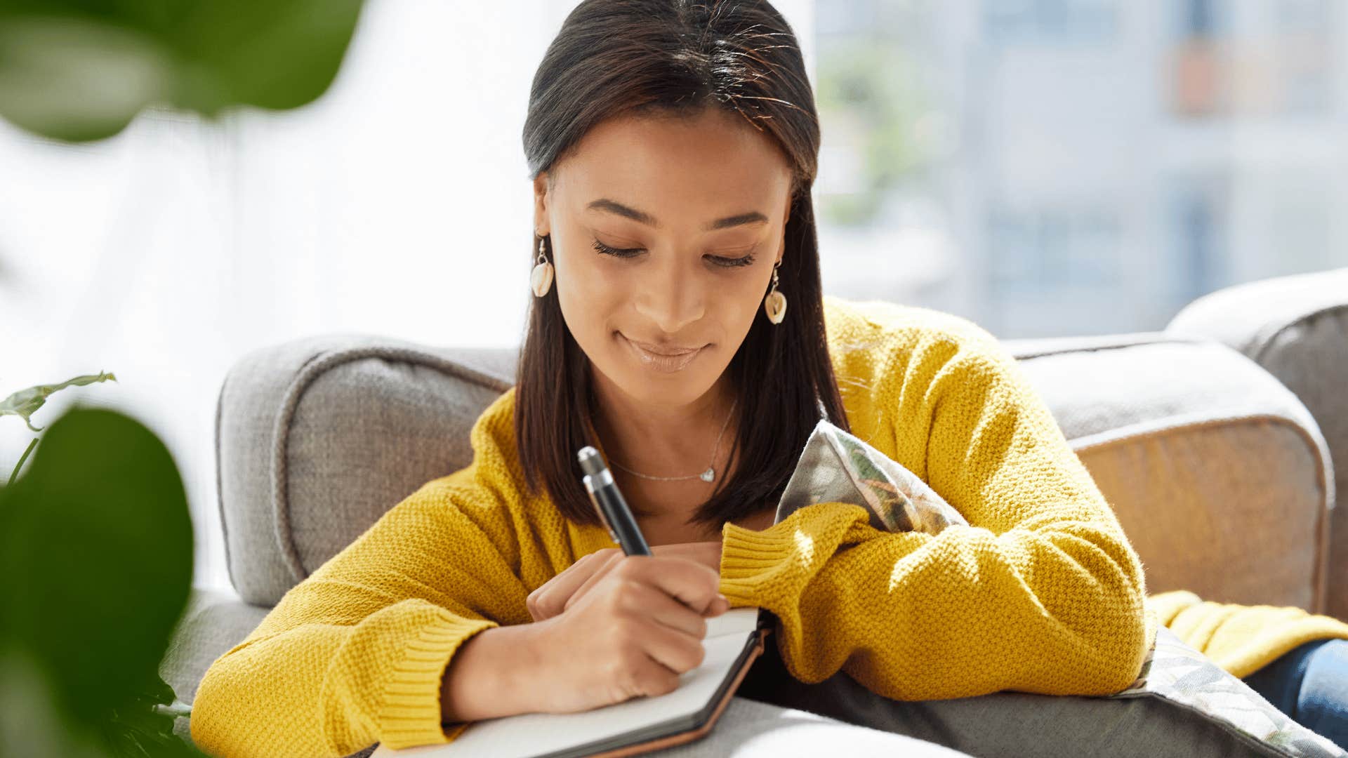 happy woman writing down her thoughts in a diary