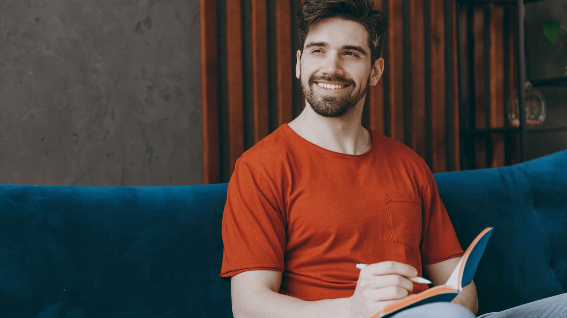 smiling man writing poetry at home