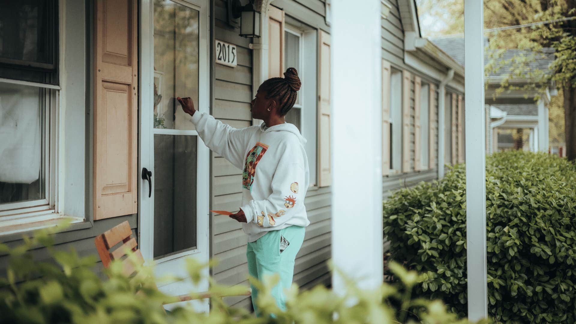 young girl knocking on a friend's door in neighborhood