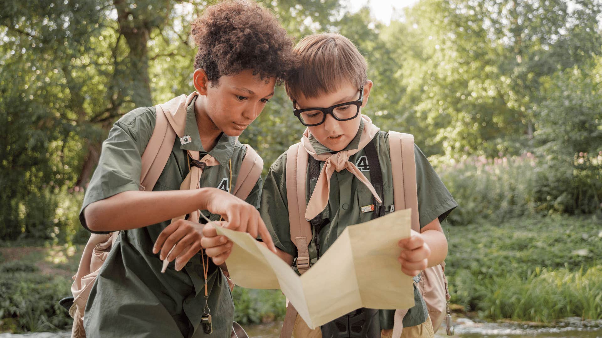 young kids using paper maps to explore